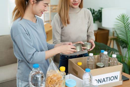 charity, donation and volunteering concept. Volunteer prepare foodstuff box containing food to donate to people poor, disaster victim at home.