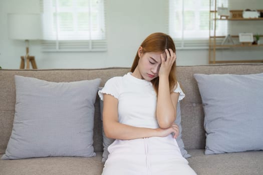 Woman has headache dizzy, holding her head in his hands because had headache and burning temperature.