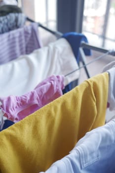 close-up of wet laundry hanging and drying on a wire room dryer