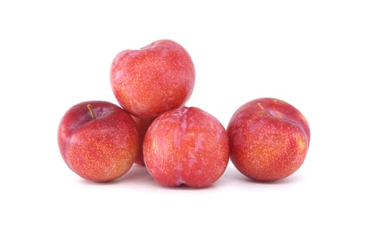 Four crimson plums arranged against a white background