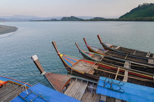 Close pu small fishing boats anchored in the sea during sunset in Thailand