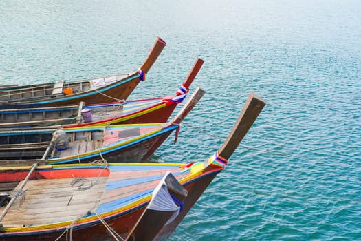 Close pu small fishing boats anchored in the sea during sunset in Thailand