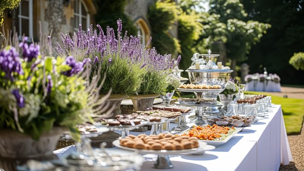 Wedding table decoration with lavender flowers, sweets, cake and candles