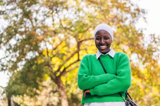 muslim black woman laughing happy looking at camera, concept of tradition and modern lifestyle, copy space for text