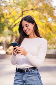 brunette woman smiling happy using her mobile phone, concept of technology of communication and modern lifestyle