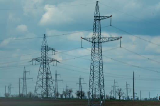 High voltage towers with sky background. Power line support with wires for electricity transmission. High voltage grid tower with wire cable at distribution station. Energy industry, energy saving.