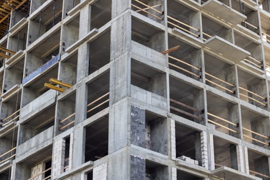 A tower block under construction, featuring a facade with numerous windows and balconies. The property is being built using composite materials, designed for urban living in a condominium