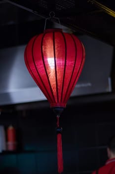 The restaurant is adorned with a row of colorful lanterns hanging from the ceiling, creating a vibrant atmosphere in the room