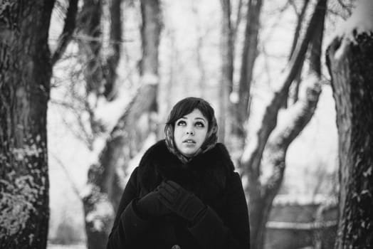 black and white portrait of a girl in a shawl in the winter in the woods