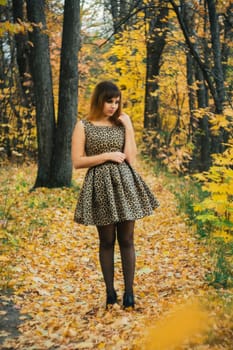 girl in dress and heels posing in autumn in the woods