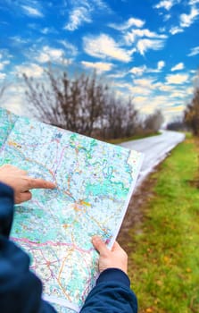 A man looks at a map on the road. Selective focus. People.