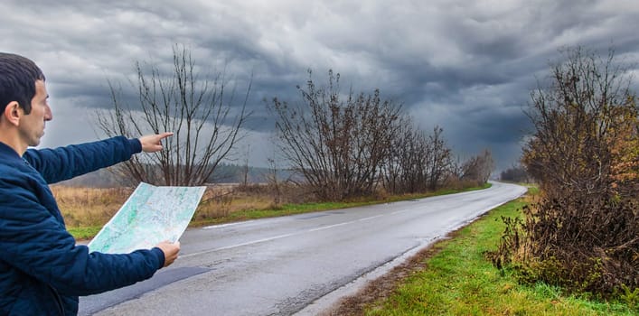 A man looks at a map on the road. Selective focus. People.