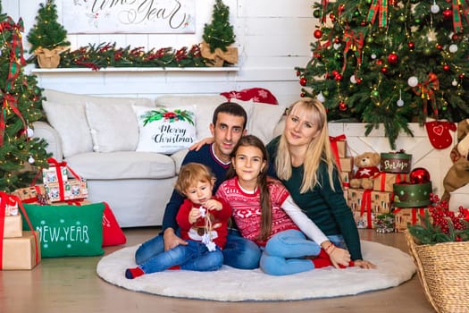 Family photo near the Christmas tree. Selective focus. Holiday.