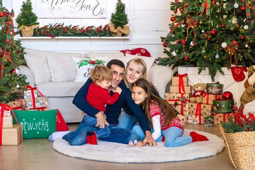 Family photo near the Christmas tree. Selective focus. Holiday.