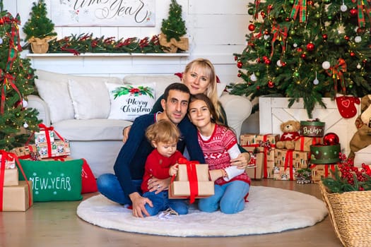 Family photo near the Christmas tree. Selective focus. Holiday.