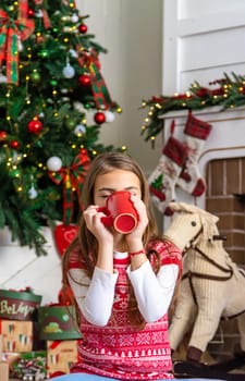 Children drink tea near the Christmas tree. Selective focus. Kid.
