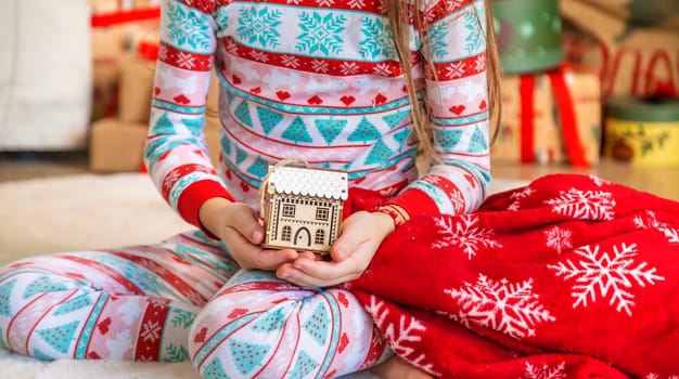 Christmas toy house child in hands. Selective focus. Kid.