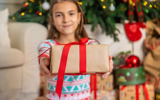 Children near the Christmas tree with a gift. Selective focus. Kid.