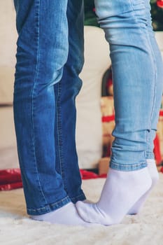 Legs of lovers near the Christmas tree. Selective focus. People.