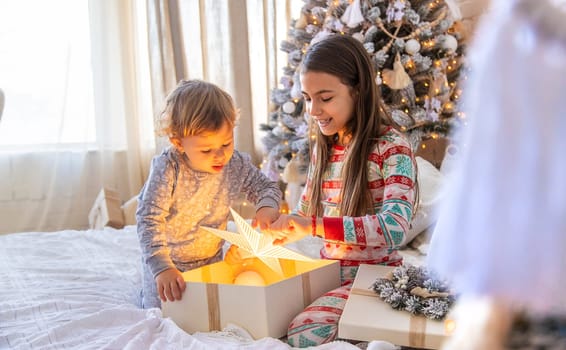 Child open Christmas gifts under the tree. Selective focus. Kid.