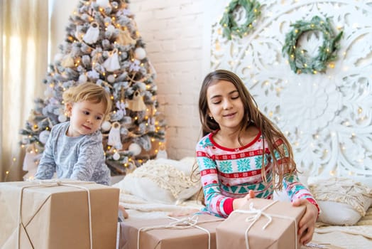 Child open Christmas gifts under the tree. Selective focus. Kid.