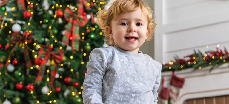 child near the christmas tree. Selective focus. Kid.