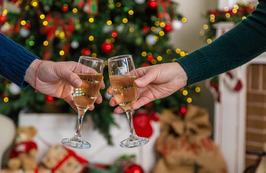 Man and woman with champagne in their hands near the Christmas tree. Selective focus. Couple.