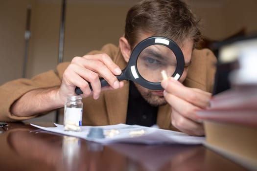 the investigator examines the evidence through a magnifying glass.