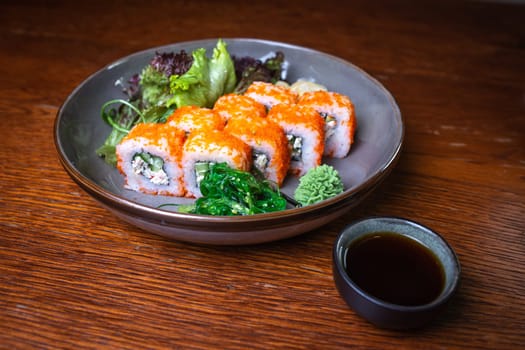 rolls with red caviar, wasabi, nori on a plate. Japanese kitchen.