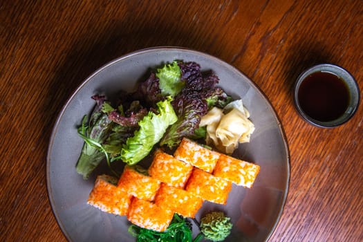 Japanese cuisine, sushi rolls with red caviar on a plate, top view.