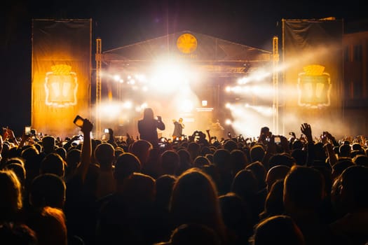 KINESHMA, RUSSIA - AUGUST 30, 2018: Live concert of the popular Russian rap singer Basta on stage from the label Gazgolder. Silhouettes of the audience on a musical night performance