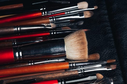 set of professional makeup brushes in leather black case close-up