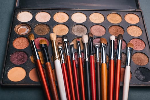 makeup brush set and professional eye shadow palette to make feminine beauty