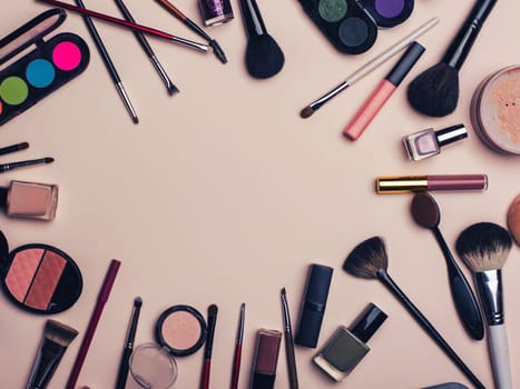 set of beauty cosmetics for female face and eye makeup on pink background with copy space. Top view