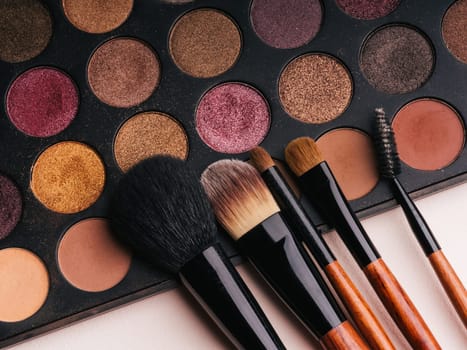 makeup brush set and professional eye shadow palette close up