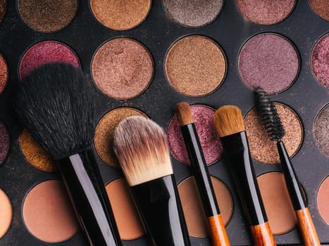 makeup brush set and professional eye shadow palette close up