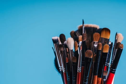 close-up makeup brush set for coloring eyes on blue background