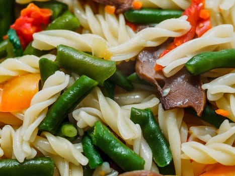 fusilli pasta with vegetables and mushrooms on a plate