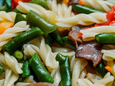 fusilli pasta with vegetables and mushrooms close-up