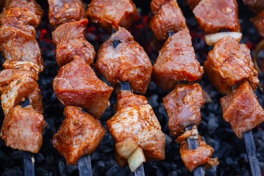barbecue of pork is prepared on skewers on the grill for a summer picnic
