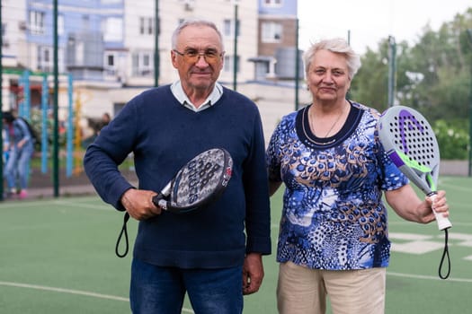 Ukraine, Kyiv, May 05, 2024, Happy cheerful positive smiling padel players of different generations posing on padel court. High quality photo