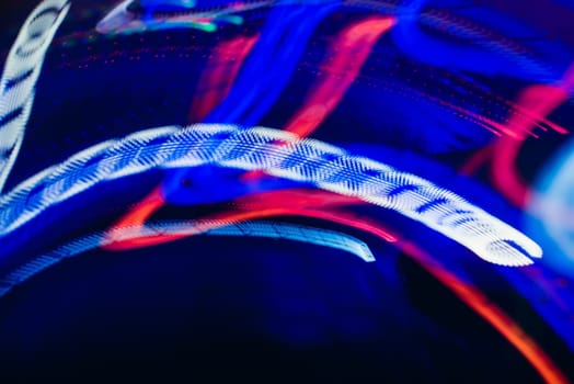DJ mixer in a nightclub with glowing colored lights from controllers and buttons in the nightclub