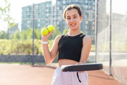 Teenage girl holding padel racquet in hand and ready to return ball while playing in court. High quality photo