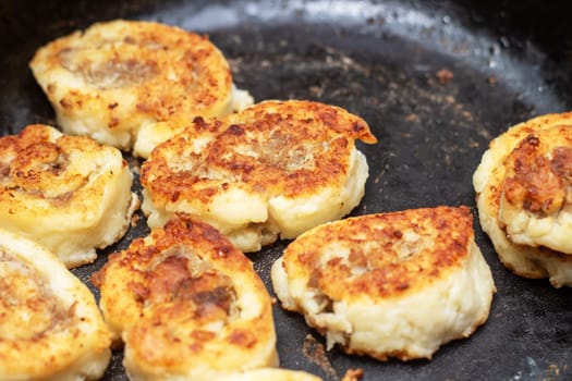 A cut of meat is sizzling in a frying pan, being cooked to perfection. This dish is a classic example of deep frying in cuisine, creating a delicious fried food ingredient