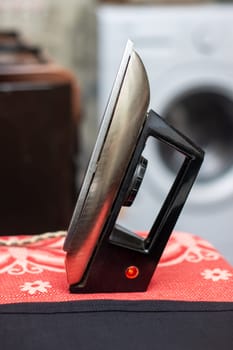 A black iron representing Automotive design is displayed on a red tablecloth alongside wood representing Auto parts in a stylish setting