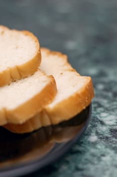 Food ingredients like slices of meat and bread served on a black plate