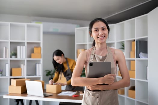 Asian woman working with tablet in online business office.