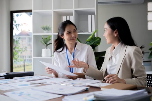 Team businesswomen discussing financial reports in office.