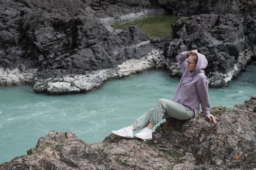 Woman at the river Katun at summer day. Trip on Altai Mountains in Altai Republic