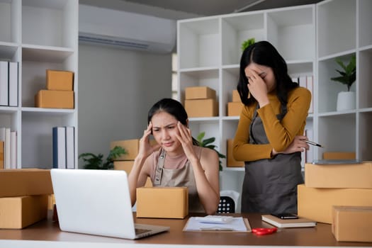 Stressed young women in warehouse, dealing with packaging issues and inventory problems.